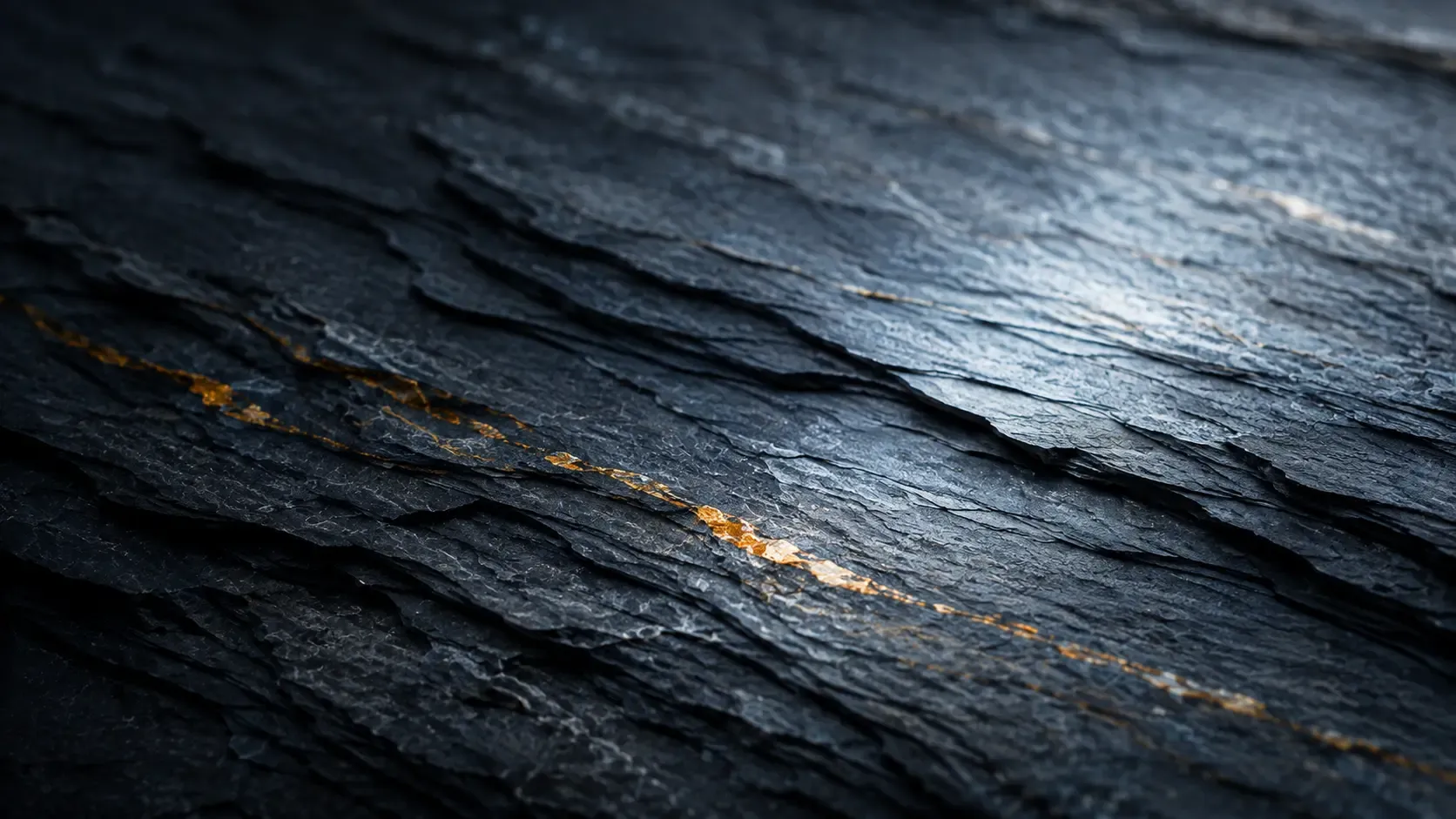 Layered rock strata in cool grey and slate tones with a soft diagonal light sweep.